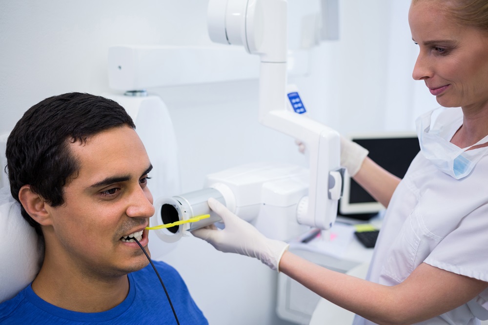 Dentist taking a male patients tooth x-ray in clinic