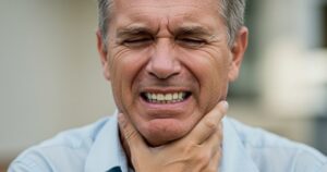 a man suffering from pain, wishing to cure TMJ permanently