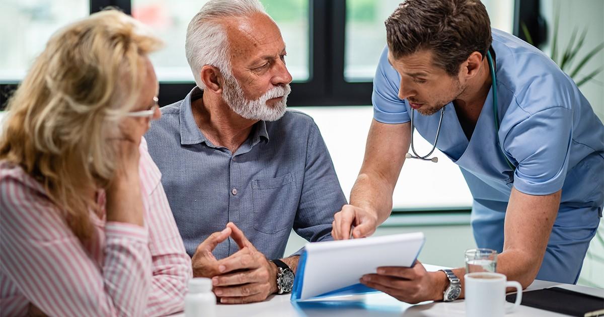 Dentist explaining coverage options to senior patients while reviewing best dental insurance in Toronto.