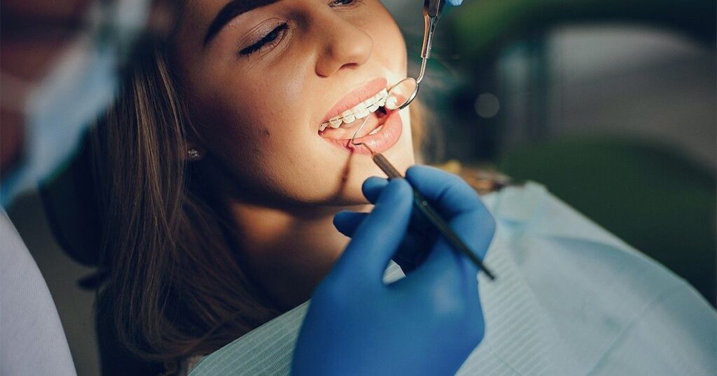 Orthodontist adjusting braces during Invisalign vs Traditional Braces consultation and treatment.