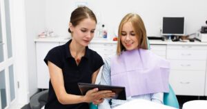 An orthodontist shows a likely outcome to the patient during the Invisalign consultation.